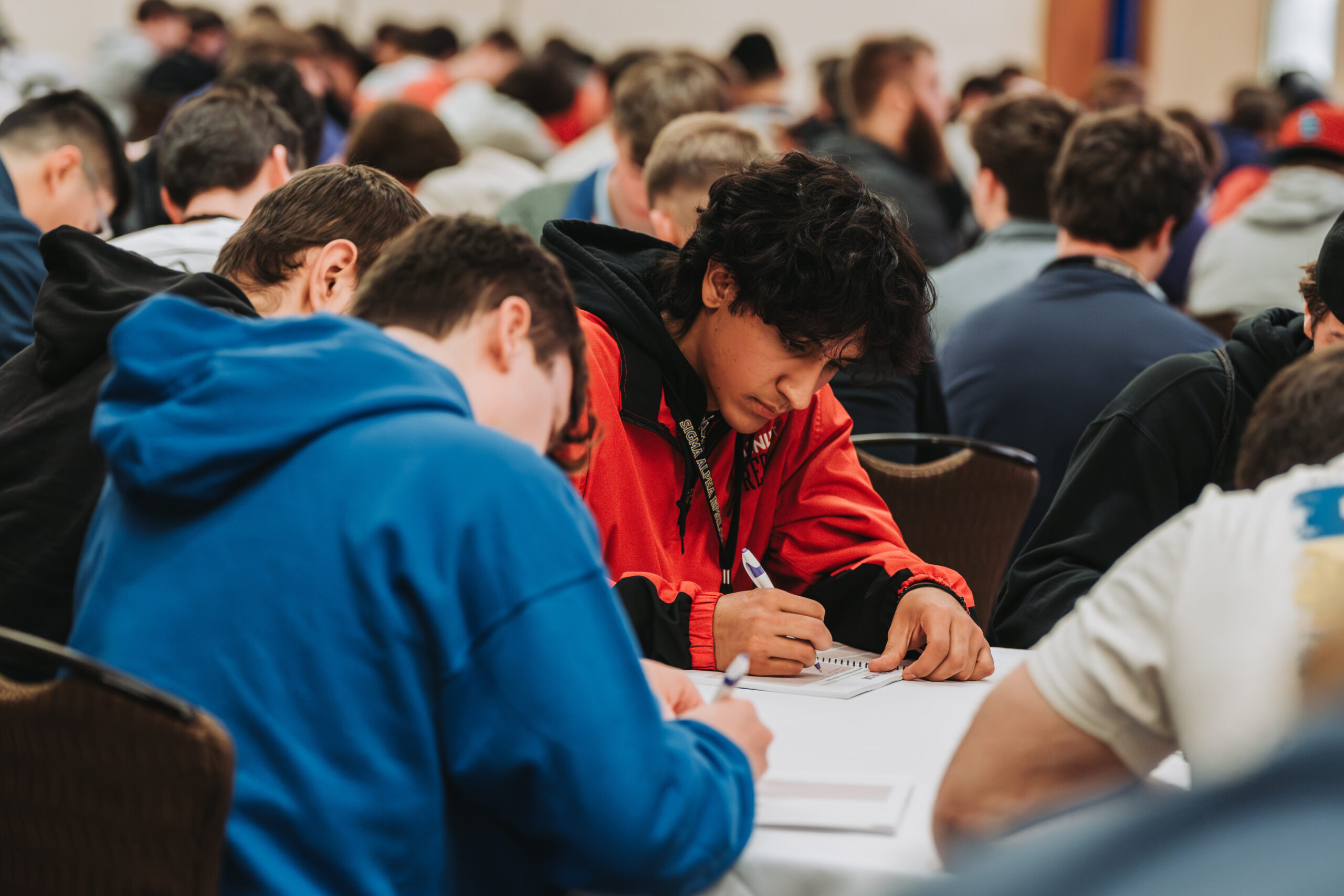 SAE brothers writing at a conference table at the SAE 85th National Leadership Conference